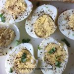 hard boiled eggs halved with sprinkle of salt and paper kept on a white plate